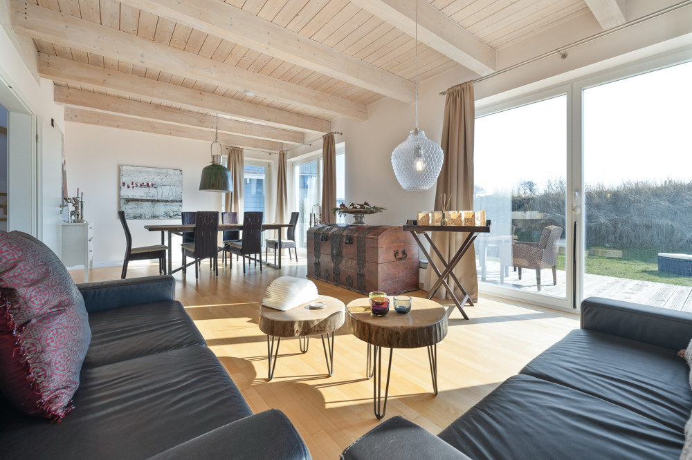 Nordisches Wohngefühl in Meeresnähe - Helles Wohnzimmer mit großer Fensterfront und gemütlicher Essecke