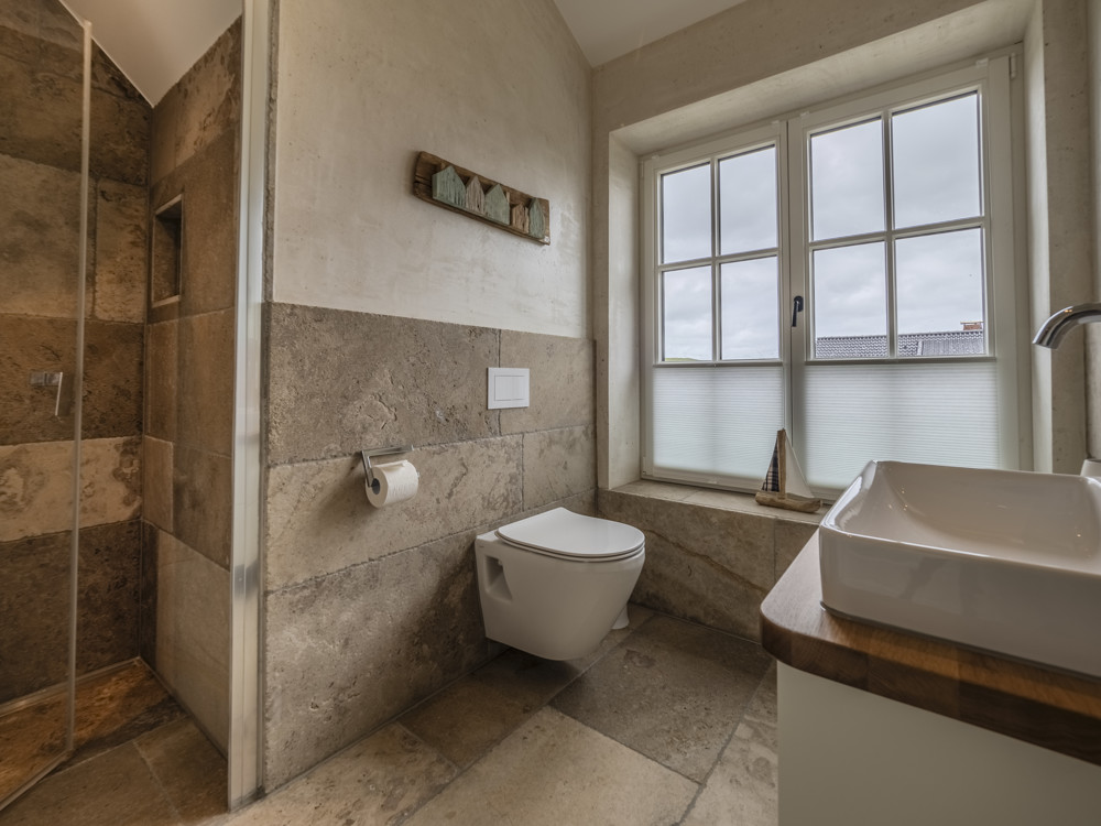 Strandnah, exklusiv und großzügig – Neubauhaushälfte in ruhiger Lage von Rantum - Große Natursteinfliesen im Badezimmer